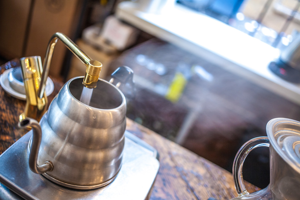A premium stainless steel water jug featuring a mirror-polished finish, a gold-toned laser-printed floral motif, and a decorative lid knob.